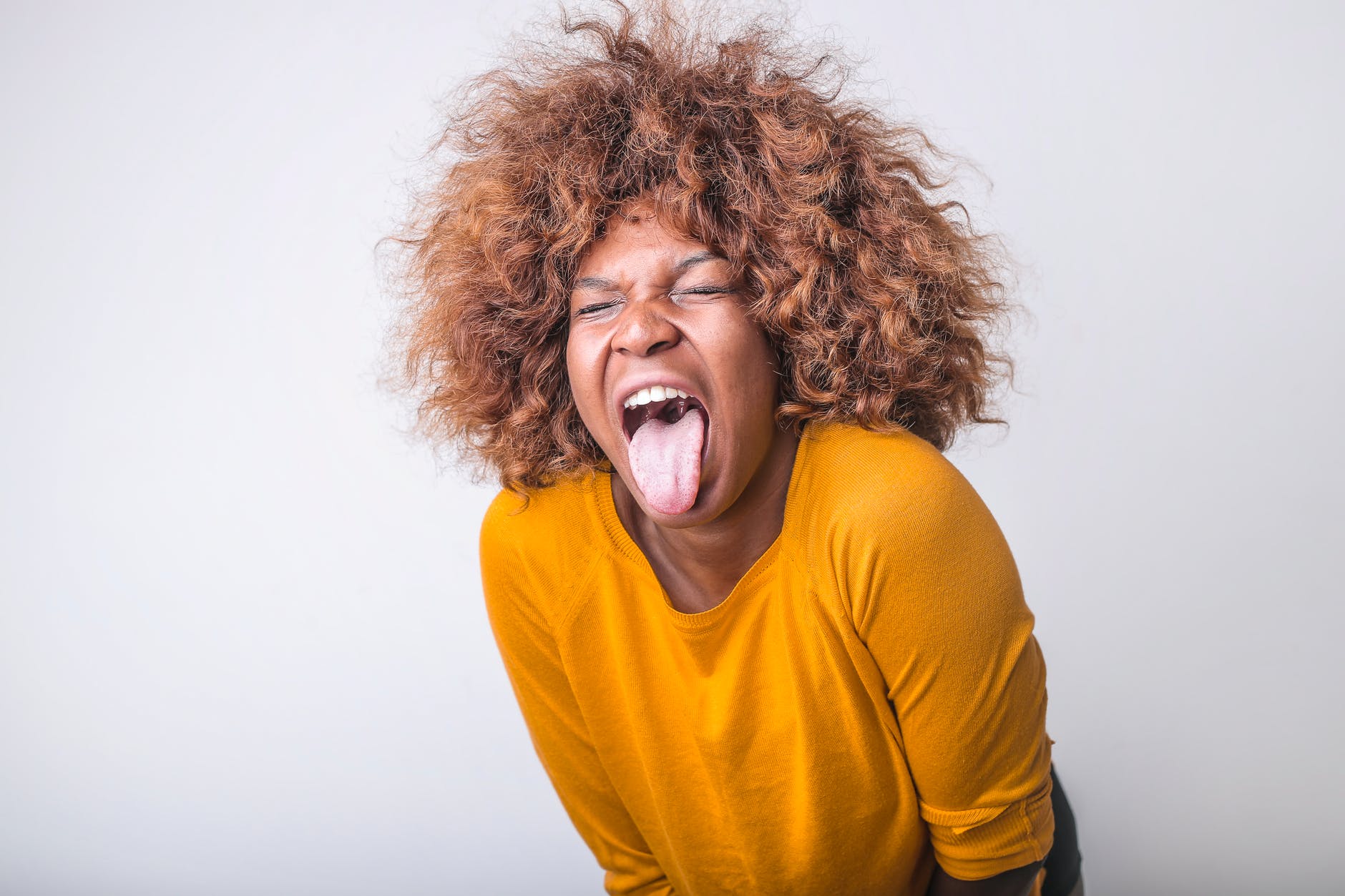 grimacing ethnic woman with tongue sticking out in studio